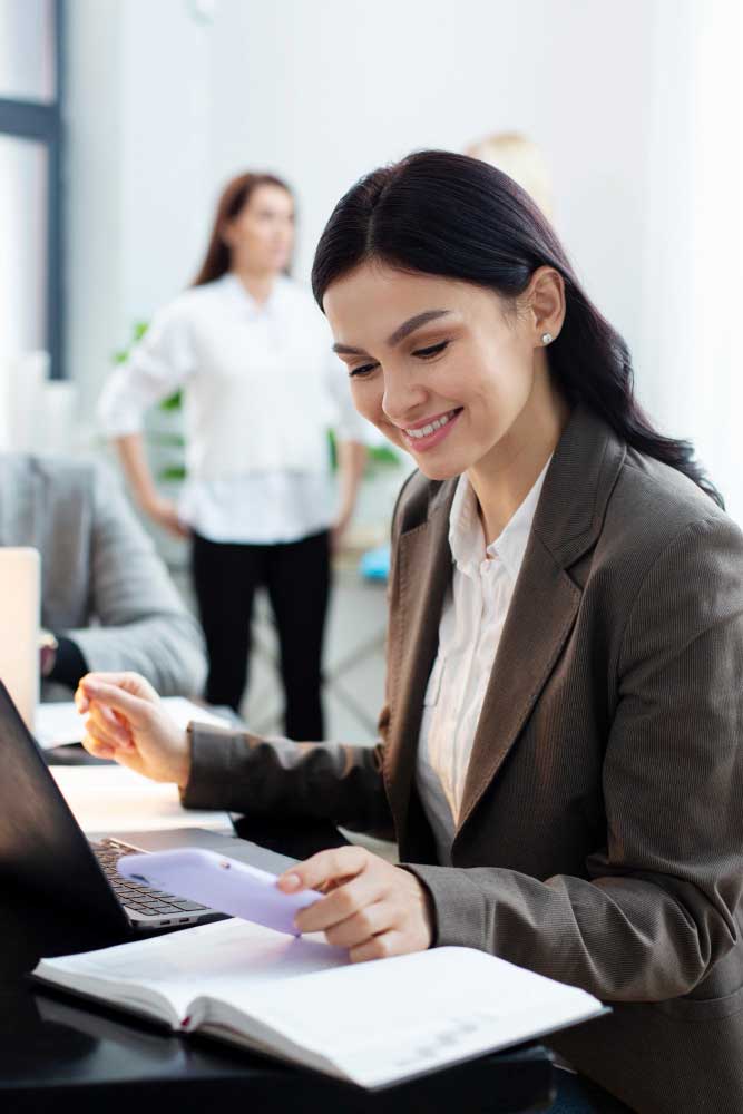cpa fort lauderdale professional reviewing financial documents and working on a laptop in a modern office environment