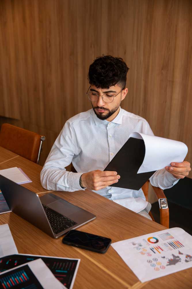 cpa fort lauderdale professional reviewing financial reports and business analytics while working at a desk in a modern office
