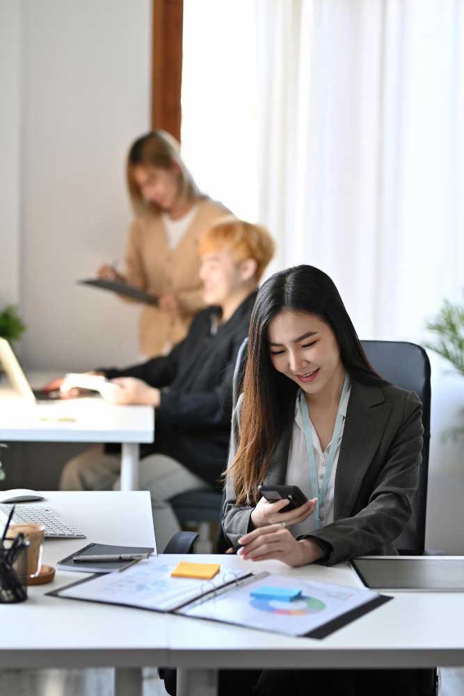 Professional accountant reviewing financial charts on phone in modern office, offering trusted cpa fort lauderdale services