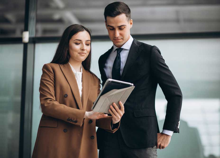 business-managment-consultant-miami Business Financial Consultant Miami reviewing financial data on a tablet with a client in a professional office setting
