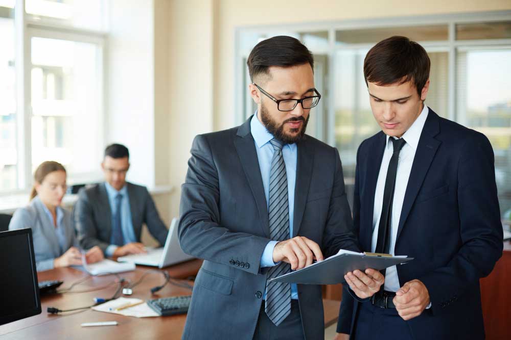 business-financial-consultant-8 Two professionals reviewing documents in a modern office meeting, providing expert business financial consultant Fort Lauderdale services