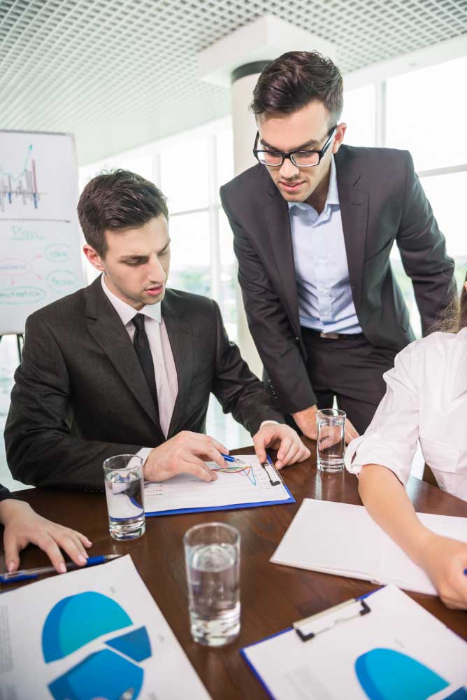 business-consultant-miami Business professionals reviewing charts and financial reports during a strategy meeting with a business financial consultant miami