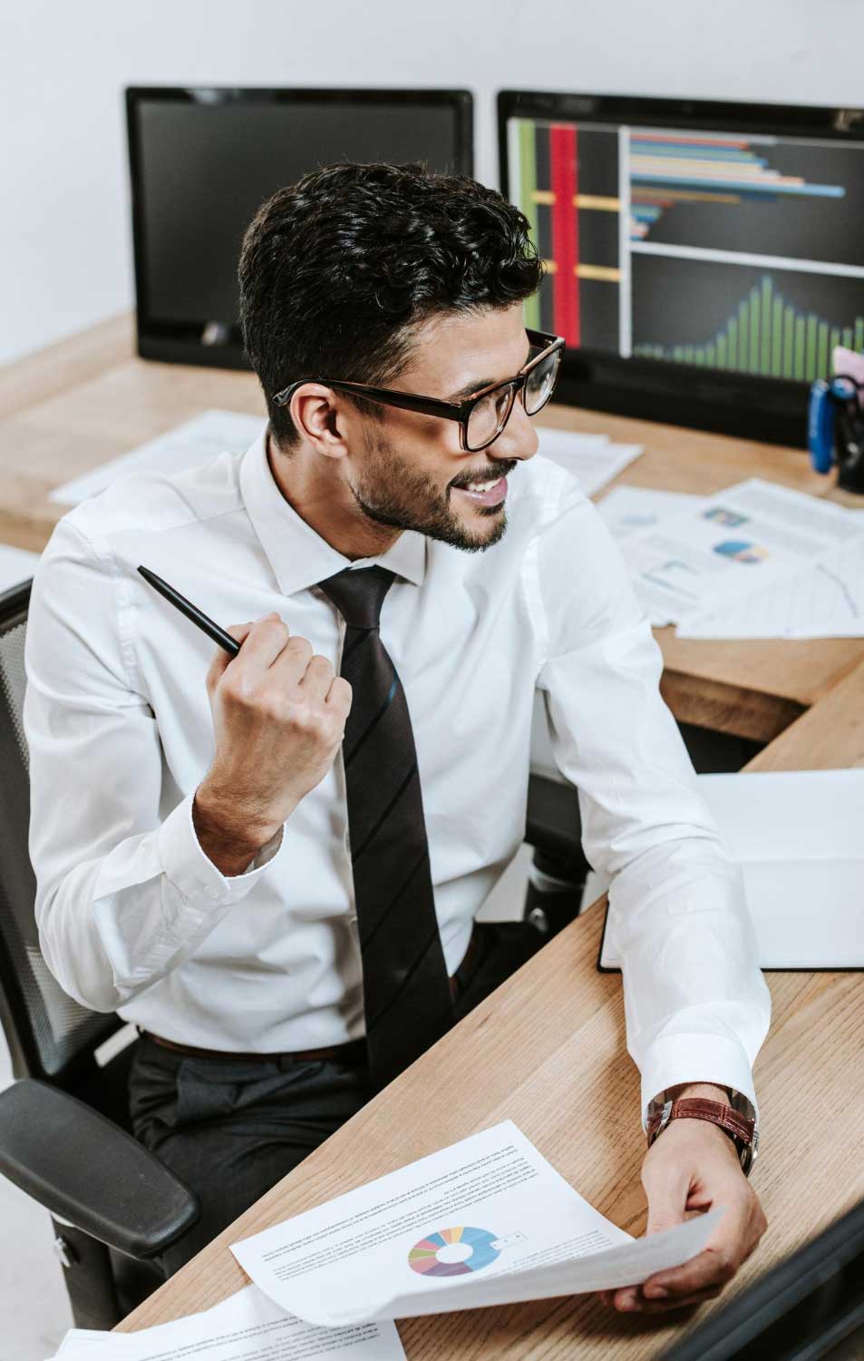 tax-refund-miami-5 Tax professional reviewing financial documents and reports at desk while planning refunds and analysis for Tax Refund Miami services